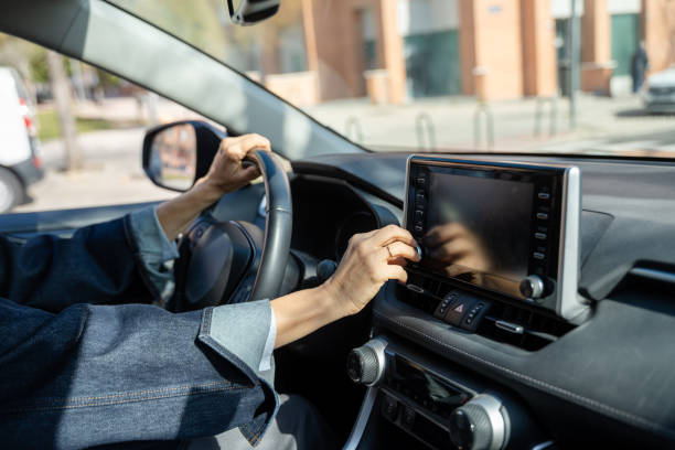 istock Woman driving car adjusting infotainment system volume control 2200930626