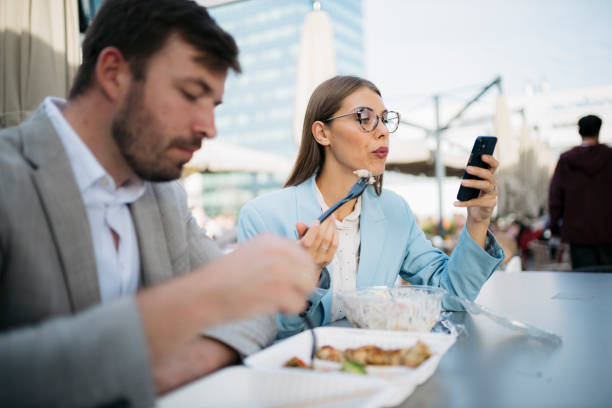 istock Business colleagues enjoying lunch break and browsing smartphone 2200933525