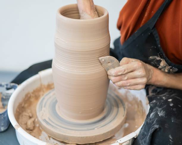 istock Close-up of a potter's hands making a ceramic vase on a potter's wheel. 2200937738