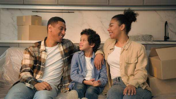 Happy joyful parents mom dad little child boy kid son together on couch relocation moving day smiling African American family home owners relax on sofa buy rent house real estate mortgage bank credit Happy joyful parents mom dad little child boy kid son together on couch relocation moving day smiling African American family home owners relax on sofa buy rent house real estate mortgage bank credit. High quality photo mum new boyfriend stock pictures, royalty-free photos & images