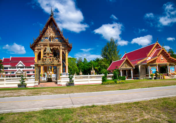 Traditional Buddhist temple Wat Choeng Thale in Phuket surrounded by lush greenery.