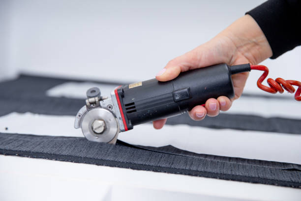 istock Tailor cutting fabric with electric cutter 2200945622