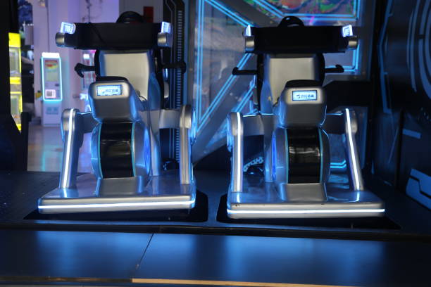 istock Two high-tech sci-fi chairs on display at an arcade, with a sci-fi theme and a black and blue color scheme, featuring LED lights. 2200950373