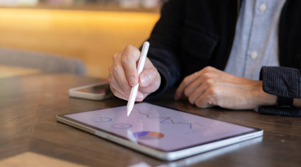 istock close up executive employee accounting man hand using stylus pen to pointing on tablet screen to show company profit monthly in the meeting event at conference room , business strategy concept 2200951707