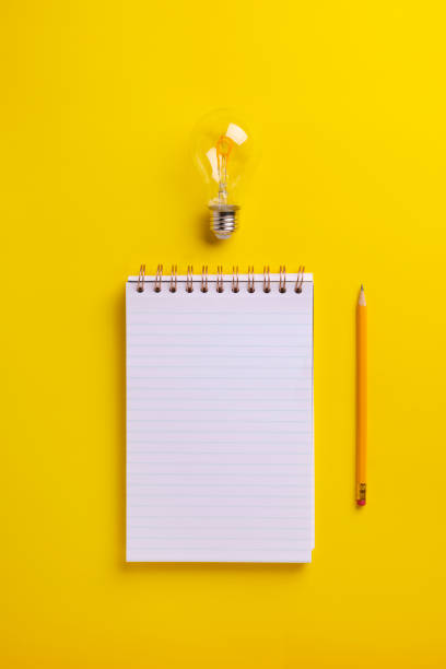 istock Creative Writing with notepad light bulb and pencil on a yellow background 2200953195