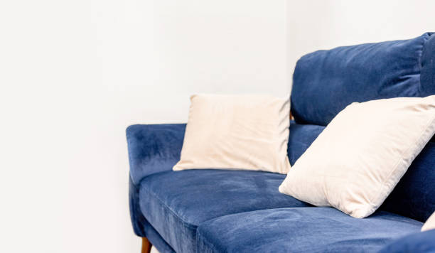 istock A navy sofa and white cushions that stand out in a white room. 2200959444