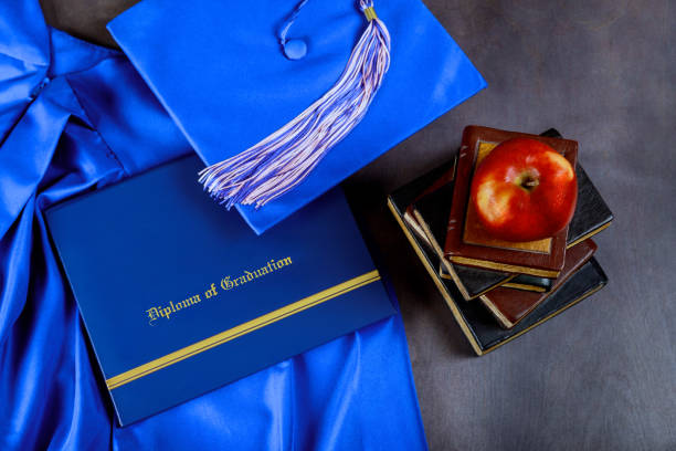 A young woman in a Red Graduation gown holding her cap and tassel at her side
