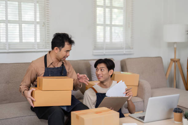 istock Two friends managing their online store, preparing packages for shipment and discussing logistics. 2200962313