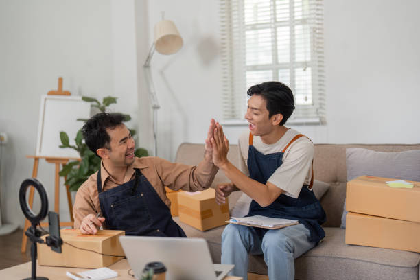 istock Two online sellers engaged in a fun brainstorming session in their stylish home workspace. 2200962477