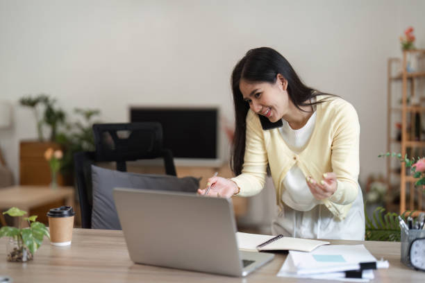 istock Young woman discussing ideas on a call while managing her laptop in a home office. 2200962965
