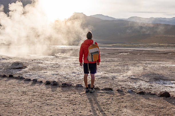 istock Man Exploring Geothermal Field at Sunrise with Backpack 2200966666