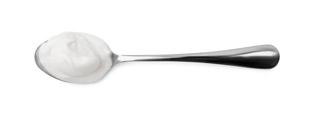 istock Delicious natural yogurt in spoon isolated on white, top view 2200968499