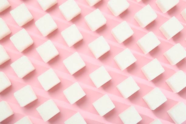 istock White sugar cubes on pink background, top view 2200968502