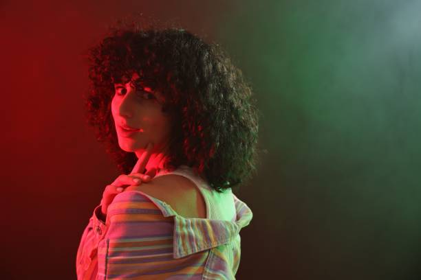 istock Beautiful young woman posing on color background in neon lights. Space for text 2200970834