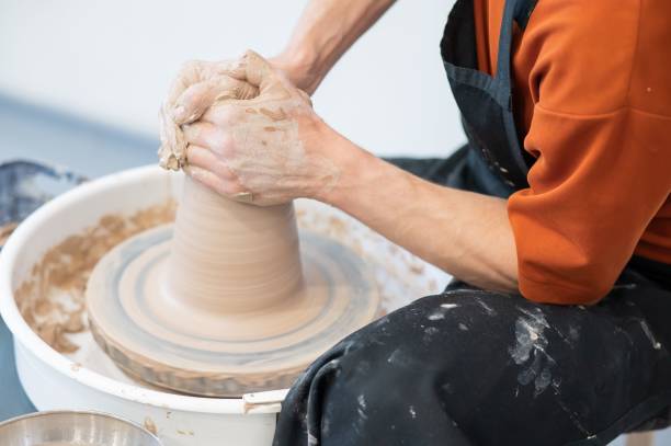 istock Close-up of a potter's hands working on a pottery wheel. 2200971080