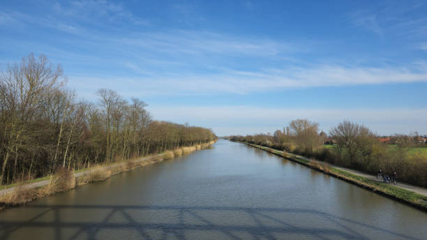 A beautiful and serene river flows gently beneath a clear blue sky, creating an idyllic scene