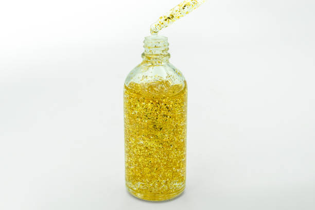 istock Dropping serum collagen moisturizer of face into clear yellow bottle soft light background. Protector skin Treatment facial essence oil, Vitamin C. Beauty and spa Concept. 2200976057
