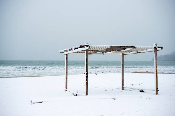 Winter landscape with a shed and an awning on the seashore - selective focus