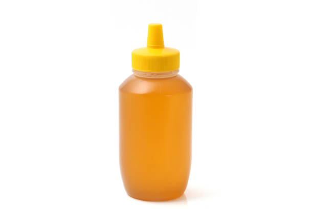 Plastic bottle of honey on isolated white background