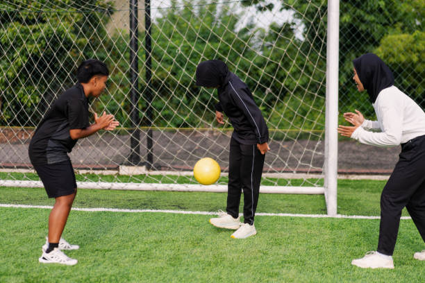Muslim Female Football Players Practicing Tricks on the Field stock photo
