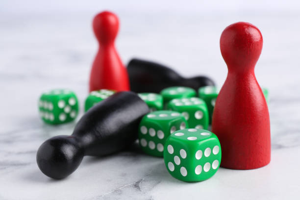 istock Green dices and color game pieces on white marble table, closeup 2200982875