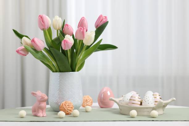 istock Composition with bouquet of tulips and Easter decorations on white table 2200984426