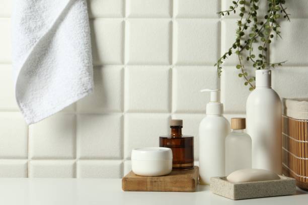 istock Different bath accessories and personal care products on white table near tiled wall 2200986539