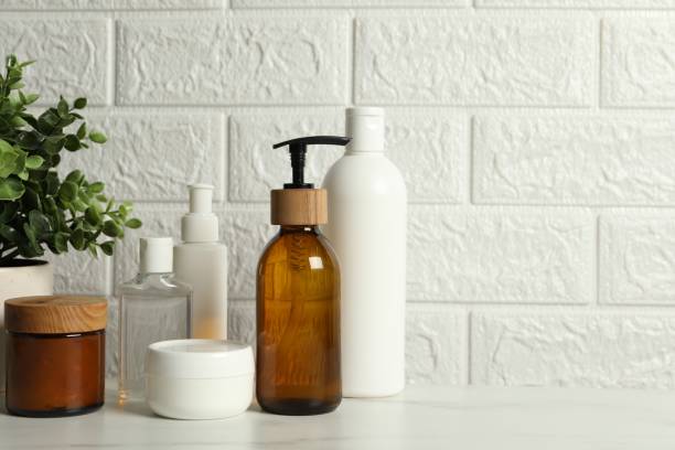 istock Bath accessories. Personal care products on white table near brick wall, space for text 2200986569