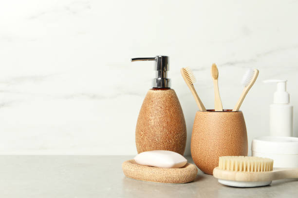 istock Different bath accessories and personal care products on gray table near white marble wall, space for text 2200986697