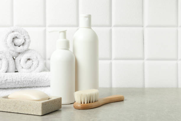 istock Different bath accessories and personal care products on gray table near white tiled wall, space for text 2200986720