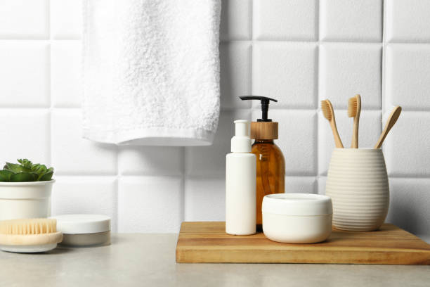 istock Different bath accessories and personal care products on gray table near white tiled wall 2200986728