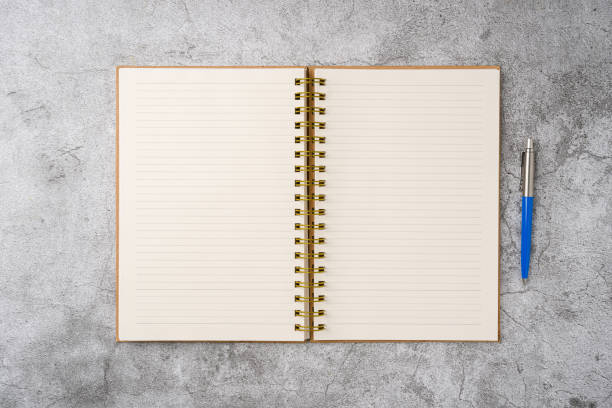 istock Top view of notebook and ballpoint pen on stone background 2200991778