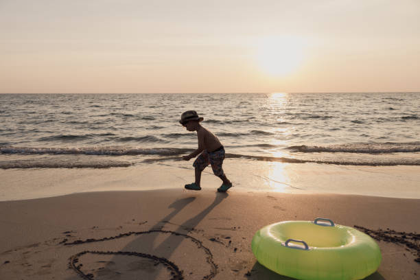 A boy Enjoying the sunset on the beach
