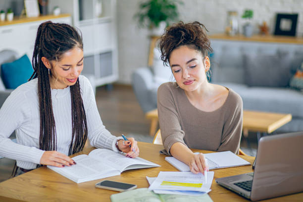istock Happy college roommates communicating while learning together at home 2201000744
