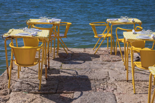 chairs and set tables along the Tagus river; Lisbon, Portugal