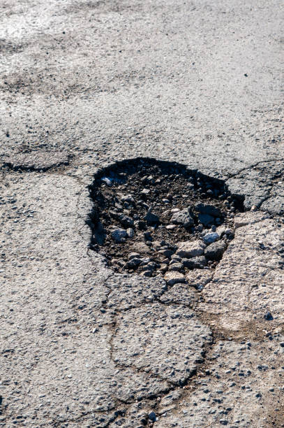istock Pothole after frost in winter on a road vertical 2201002980