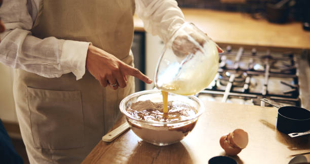 istock Family, hands or baking in kitchen for learning, teaching or child development in home. Woman, kid or pointing at ingredients for instruction, showing recipe or bonding at counter with making dessert 2201004223
