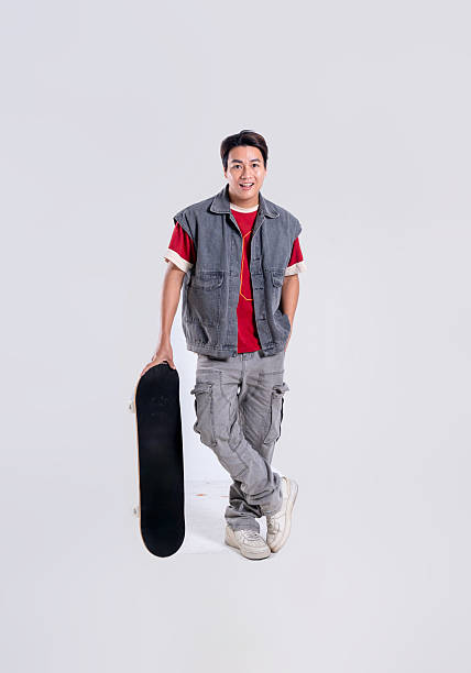 Portrait of asian man playing skateboard on white background