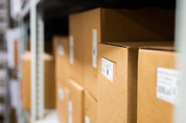 istock Warehouse goods. Rows of shelves with goods in cardboard boxes, close-up 2201006865