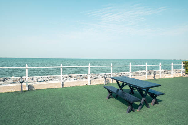 Picnic bench near beach, beach picnic background, clear blue sky with clouds on a pleasant sunny day