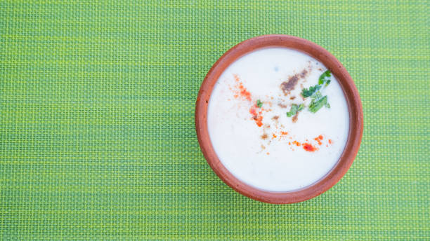 istock a cup of yoghurt in an earthen bowl on green table mat, outdoor dining restaurant 2201007779