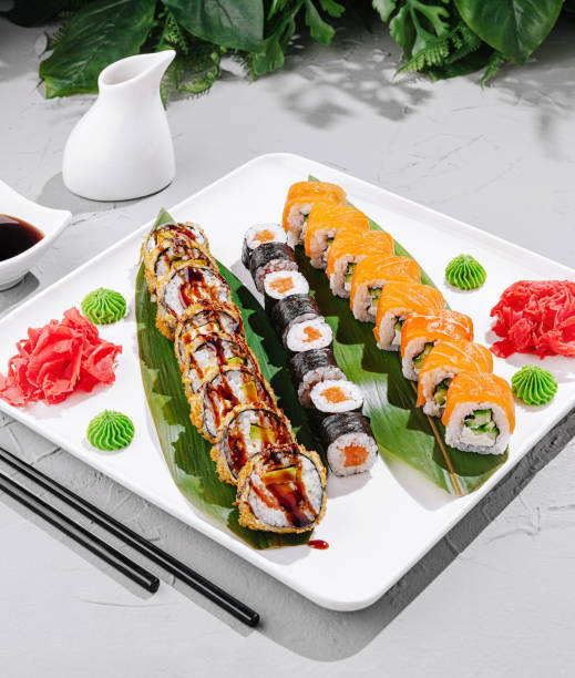 Delicious sushi platter featuring various rolls and garnishes served on a white plate