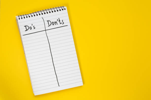 istock Do's and Don'ts list on a spiral notebook page isolated on vibrant yellow background 2201008740