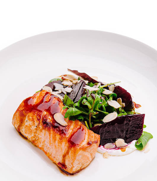 istock Deliciously plated salmon with greens and beets presented elegantly on a white dish 2201008763
