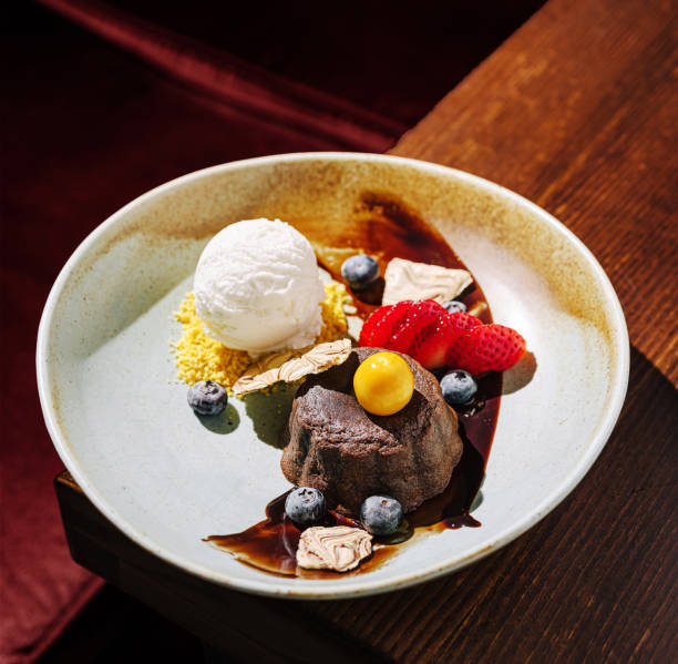 istock Delightful dessert featuring chocolate cake, fresh fruits, and ice cream served on a rustic plate at a cozy restaurant 2201008958