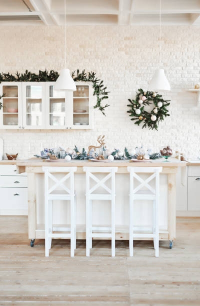 istock Interior light kitchen with christmas decor and tree. White kitchen in classic style. Christmas in the kitchen. Bright kitchen in white shades with Christmas. 2201010274