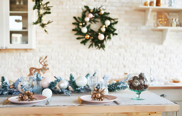 istock Interior light kitchen with christmas decor and tree. White kitchen in classic style. Christmas in the kitchen. Bright kitchen in white shades with Christmas. Christmas table setting. 2201010285