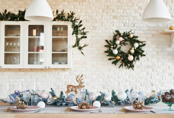 istock Interior light kitchen with christmas decor and tree. White kitchen in classic style. Christmas in the kitchen. Bright kitchen in white shades with Christmas. Christmas table setting. 2201010297