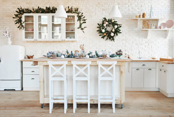 istock Interior light kitchen with christmas decor and tree. White kitchen in classic style. Christmas in the kitchen. Bright kitchen in white shades with Christmas. 2201010327