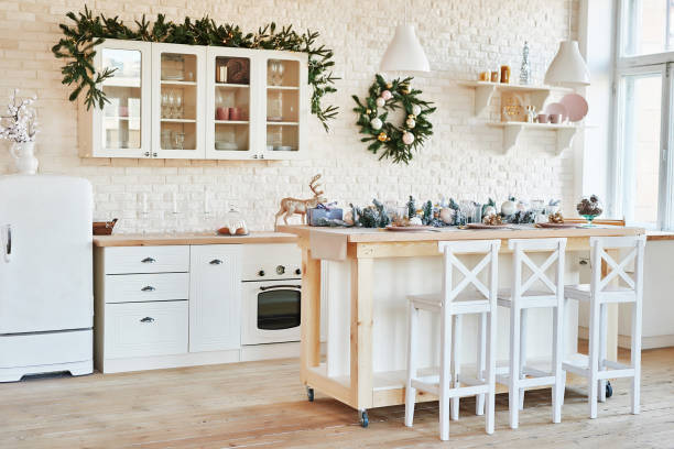 istock Interior light kitchen with christmas decor and tree. White kitchen in classic style. Christmas in the kitchen. Bright kitchen in white shades with Christmas. 2201010511